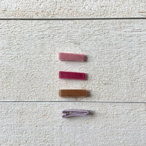 May include: Three velvet hair clips in pink, burgundy, and brown, and one lavender velvet hair clip.