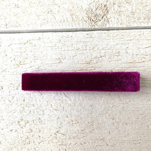 May include: A dark purple velvet hair clip.