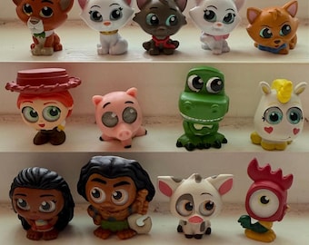 May include: A collection of 24 small, colorful, plastic figurines of popular Disney characters. The characters include Maleficent, Snow White, Ariel, Belle, Cinderella, Rapunzel, Mulan, Tiana, Moana, Elsa, Anna, Olaf, Woody, Buzz Lightyear, Jessie, Rex, Hamm, Bo Peep, Mr. and Mrs. Incredible, Frozone, Violet, Dash, and Jack-Jack.