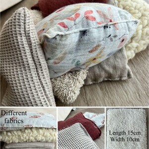 以下が含まれることがあります： ベージュ、白、グレー、赤など、さまざまな生地と色でできた、6個セットと3個セットの装飾用枕。枕は、ワッフル織り、ふわふわ、滑らかなど、さまざまな質感で作られています。画像には、「Set of 6」と「Set of 3」のテキストが表示されています。「Different fabrics」というテキストも画像に表示されています。「長さ15cm 幅10cm」というテキストも画像に表示されています。