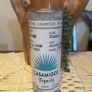 May include: A silver glitter tumbler with a white label that says "Casamigos Tequila" with a blue agave plant graphic. The label also says "Clase Blanco", "Hecho Jalisco", and "100% Agave Azul".