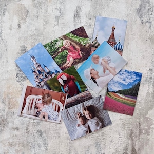 Może przedstawiać: Sześć fotografii ułożonych jest na teksturowanej, jasnoszarej powierzchni. Zdjęcia przedstawiają r&oacute;żne motywy, w tym czerwonego papugę, zamek, rodzinę i krajobraz miejski.