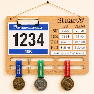 May include: Wooden race bib and medal display board with the name "Stuart's" engraved at the top. The board features a race bib with the number 1234 and a 10K label, plus slots for medals. Includes race times and target times.