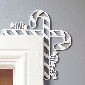 May include: White, decorative, candy cane and candy design, made of wood, for a door corner.