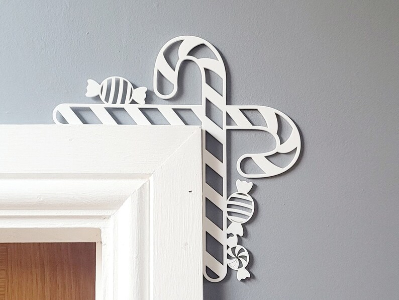 May include: White, decorative, candy cane and candy design, made of wood, for a door corner.
