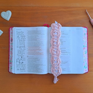 May include: A pink crocheted bookmark with a tassel hangs from a Bible open to Psalm 34:8, which reads "Taste and see that the Lord is good. Oh, the joys of those who take refuge in him!"