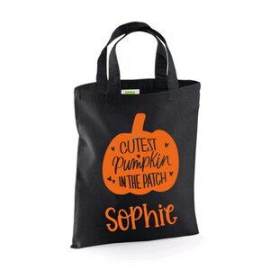 Puede incluir: Bolsa de lona negra con un gr&aacute;fico de calabaza naranja y el texto "Cutest Pumpkin in the Patch" y el nombre "Sophie".