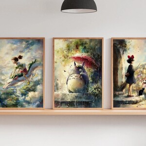 K&ouml;nnte beinhalten: Drei gerahmte Kunstdrucke mit Aquarellillustrationen. Die Drucke zeigen Szenen aus einem Zeichentrickfilm, darunter ein M&auml;dchen, das auf einem Drachen reitet, eine gro&szlig;e Kreatur unter einem Regenschirm und ein M&auml;dchen mit einer schwarzen Katze. Die Rahmen sind hellbraun.
