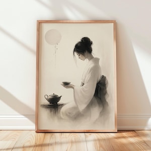 May include: A framed wall art print featuring a monochromatic ink wash style illustration of a person with hair in a bun wearing a kimono, holding a small bowl while seated near a teapot on a table, set against a pale background with a circular moon.