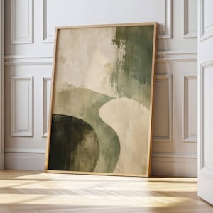 May include: A rectangular wall art print in a light wood frame featuring an abstract composition of layered organic shapes in shades of sage green, olive, and cream. The artwork displays textured brushstrokes and blended colour gradients.