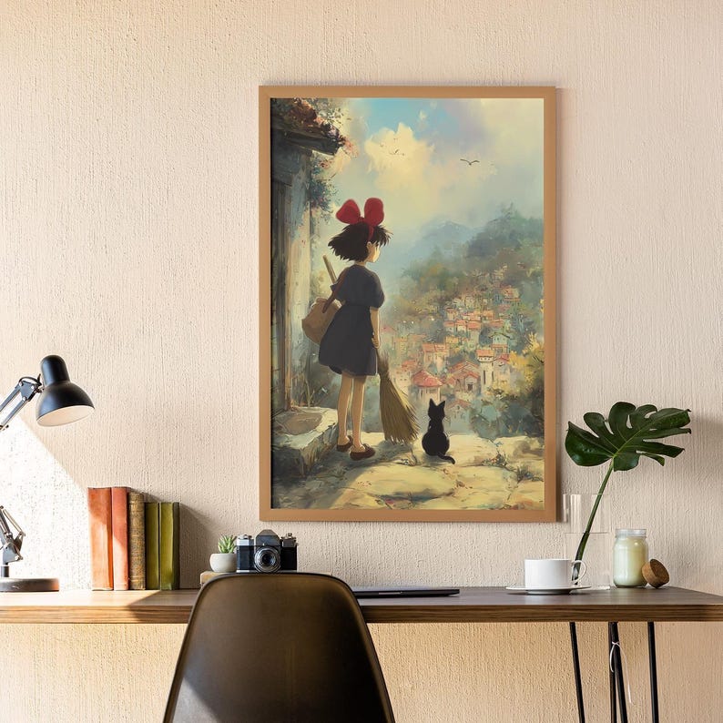 May include: A framed print of a watercolor painting featuring a young girl with a red bow, a black cat, and a broom. The girl is looking out over a village. The artwork has a soft, dreamy quality with a warm color palette.