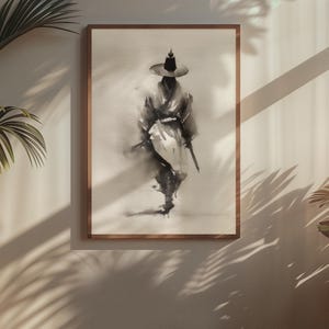 Pode incluir: Uma impress&atilde;o art&iacute;stica emoldurada com uma pintura a tinta preta de uma figura usando um chap&eacute;u de abas largas e vestes tradicionais. A obra utiliza tons de preto e cinza sobre um fundo texturizado branco, criando uma silhueta fluida e minimalista de uma pessoa em uma pose contemplativa.