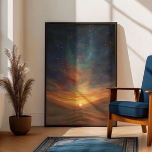 May include: A framed art print depicting a desert landscape under a starry night sky. The artwork features a vibrant sunset with shades of orange, yellow, and red, contrasted by a dark blue and green starry sky. The print is displayed in a room with a blue chair and a decorative plant.