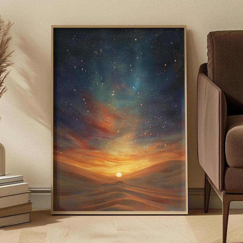 May include: Framed art print depicting a desert landscape at sunset. The artwork features rolling sand dunes under a vibrant sky with shades of orange, yellow, and blue, and a bright sun. The print is encased in a light brown frame.