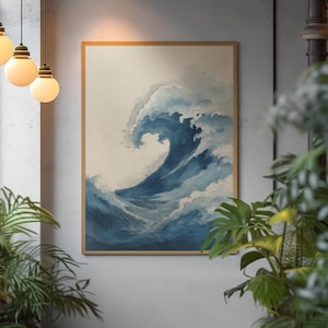 May include: A framed art print depicts a large ocean wave in shades of blue and white. The artwork is in a wooden frame and hangs on a gray wall. The image is surrounded by green plants and hanging light fixtures.
