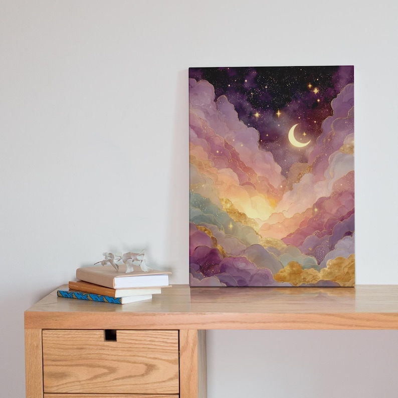 Puede incluir: Un lienzo rectangular que muestra un cielo nocturno con una luna creciente y estrellas dispersas sobre nubes ondulantes en tonos morado, rosa y dorado. La obra de arte presenta una mezcla suave y et&eacute;rea de colores con luz brillante.