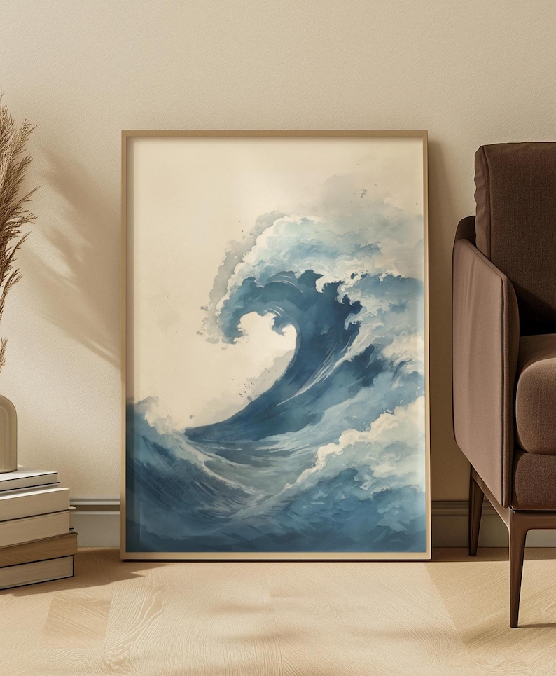 May include: A framed art print featuring a watercolor depiction of a large ocean wave. The wave is rendered in shades of blue and white, with a foamy crest and a sense of movement. The artwork is set against a neutral background.