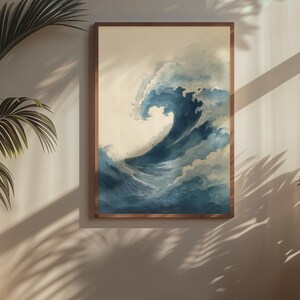 May include: A framed art print depicts a large ocean wave in shades of blue and white. The artwork is in a wooden frame and is displayed on a neutral-colored wall. The wave is the focal point, with detailed brushstrokes capturing its movement.