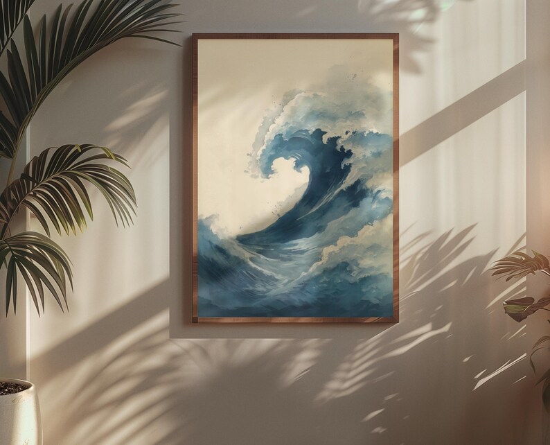 May include: A framed art print depicts a large ocean wave in shades of blue and white. The artwork is in a wooden frame and is displayed on a neutral-colored wall. The wave is the focal point, with detailed brushstrokes capturing its movement.