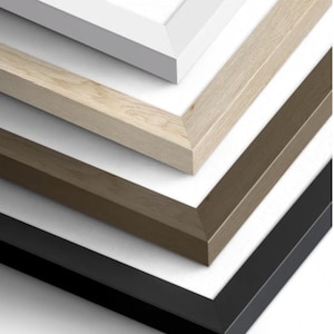 May include: A close-up view of four picture frames in different colors: white, light wood, dark wood, and black. The frames are stacked, showcasing their angled edges and the white backing.