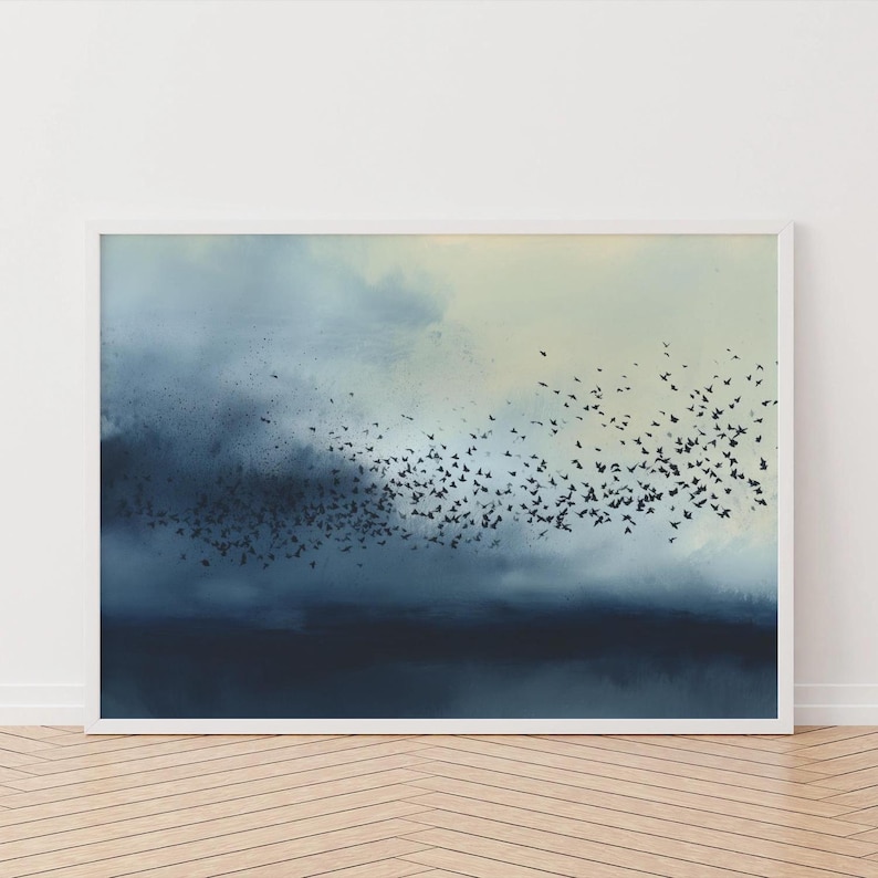 May include: A framed wall art print featuring a large flock of small black birds in flight against a moody, atmospheric background of swirling dark blue, gray, and pale cream clouds, creating a sense of movement across the horizontal composition.