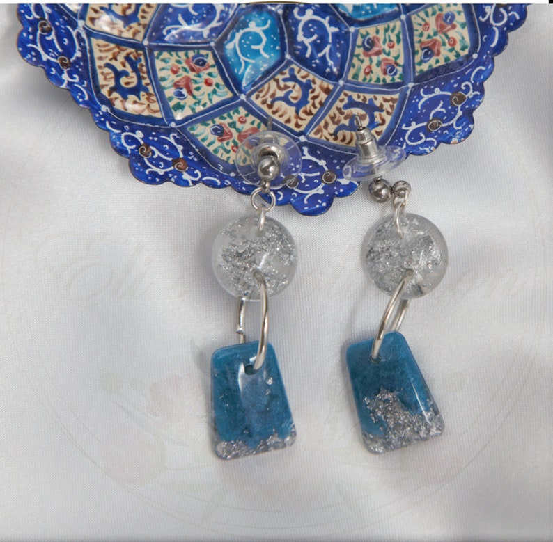 Handmade sky blue resin earrings designed with silver flakes and hypoallergenic silver attachments from Silver Sky collection.