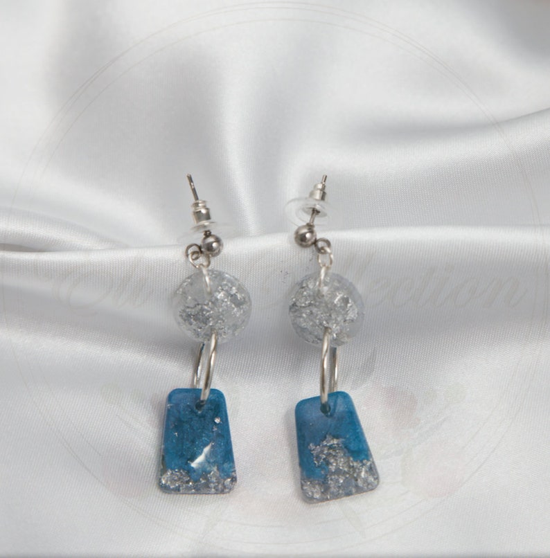 Handmade sky blue resin earrings designed with silver flakes and hypoallergenic silver attachments from Silver Sky collection.