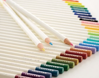 May include: A set of colored pencils with white barrels and colored tips. The pencils are arranged in a semi-circle, with the colored tips facing outward. The colors include red, orange, yellow, green, blue, purple, and brown.