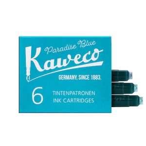 May include: A teal box of Kaweco Paradise Blue ink cartridges. The box features the Kaweco logo and the text "GERMANY, SINCE 1883." The box contains six ink cartridges, with the words "TINTENPATRONEN INK CARTRIDGES" printed on the front.