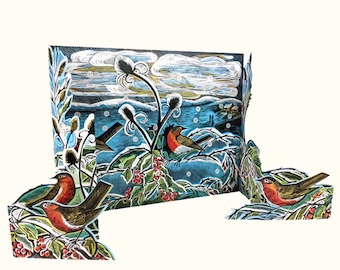 May include: A three-dimensional paper art piece depicting a winter scene with robins perched on branches with red berries. The background features a snowy landscape with a blue sky and white clouds. The artwork has a vintage, hand-drawn style.