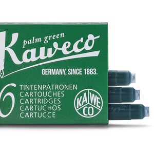 May include: A green box of Kaweco palm green ink cartridges. The box has white text that reads "Kaweco" and "Germany, Since 1883." The box contains six cartridges. The cartridges are dark green.
