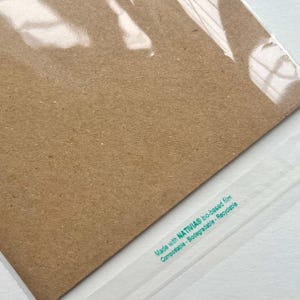 May include: Close-up of a brown paper product in a clear plastic wrap. The text "Made with NATIVIA bio-based film Compostable - Biodegradable - Recyclable" is printed in green on the plastic wrap.