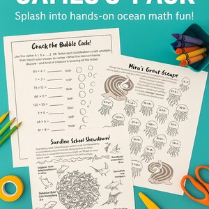 May include: Educational Ocean Math Games 3-Pack activity set. Features three printable worksheets with ocean-themed maths problems, including code-cracking and equations. Crayons, pencils, tape, and scissors are also visible.
