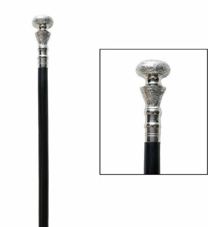 May include: A black walking cane with a silver-colored handle and decorative top. The handle has an ornate design, and the top is a rounded shape. The cane is a classic accessory.