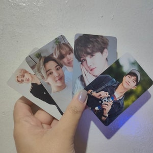 May include: A collection of four rectangular photo cards featuring portraits of various individuals. One card shows a person with a camera, while the others display close-up headshots of different people with light-colored hair and neutral expressions.