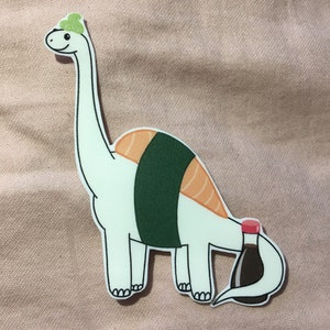 May include: A white cartoon dinosaur with a green seaweed hat and a sushi roll body. The dinosaur's tail is a bottle of soy sauce.