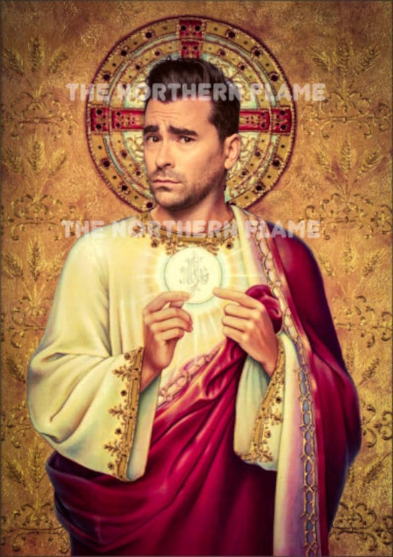 May include: A man with a serious expression is depicted in a painting, wearing a white robe with gold trim and a red sash. He is holding a round, white object with a gold design in his hands. The background is a gold and brown pattern with the text "THE NORTHERN FLAME" repeated twice.