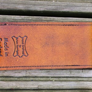 May include: A brown leather case with the text "Hand Crafted by Brian Merriman Made in England" embossed on the front.