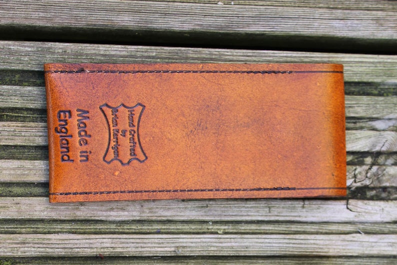 May include: A brown leather case with the text "Hand Crafted by Brian Merriman Made in England" embossed on the front.