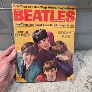 May include: Vintage magazine cover featuring The Beatles with text in red and yellow. The cover includes the text "How They Got That Way! Where They're Going!" and "The Beatles Are Here". The magazine also includes the text "Complete Life Stories" and "Autographed Pin-Ups!"