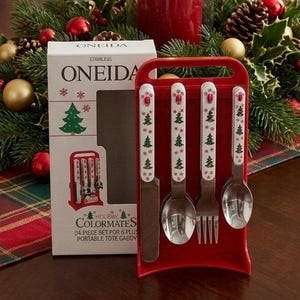 May include: A four-piece Oneida stainless steel flatware set featuring white handles with green Christmas tree and red snowflake patterns. The set includes a knife, two spoons, and a fork, displayed in a red plastic portable tote caddy.