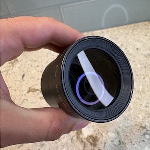 May include: A black cylindrical camera lens converter featuring a circular glass element with a purple-tinted reflection. The side of the lens barrel is clearly marked with the white text C-160 and H.D. CONVERTER, indicating its specific model type.