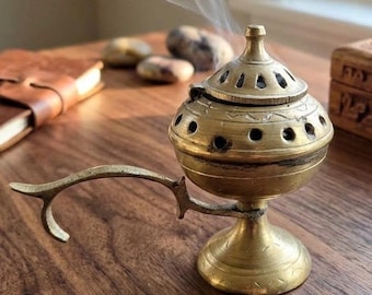 Cáliz incensario de latón vintage con tapa abatible ventilada y asa, estilo bohemio.