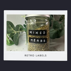 May include: A glass jar filled with mixed herbs, labelled with black and white text that reads "MIXED HERBS." The jar has a silver lid and is surrounded by green foliage. The text "RETRO LABELS" is at the bottom of the image.