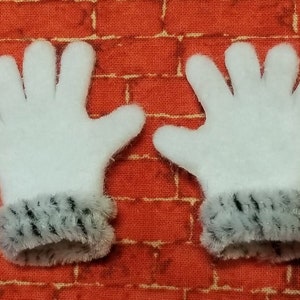 May include: A pair of white fuzzy gloves with black and white fur trim around the wrists.
