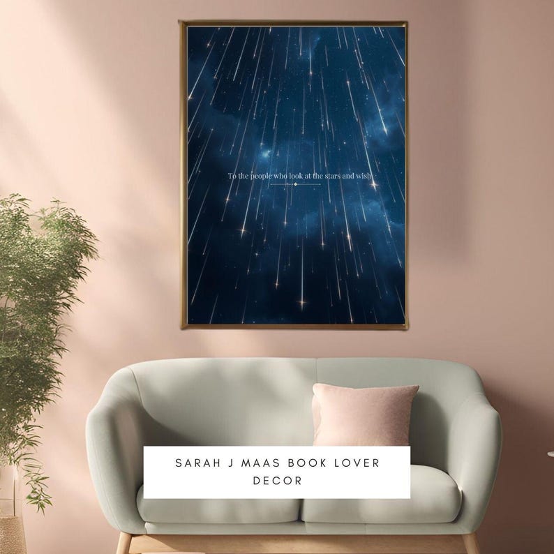 May include: A framed print with a dark blue background and white shooting stars. The print has the text "To the people who look at the stars and wish". The print is on a light pink wall above a light green sofa with a pink cushion. The text "SARAH J MAAS BOOK LOVER DECOR" is below the sofa.