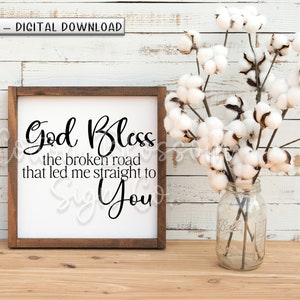 May include: A white wooden sign with a brown frame, featuring the text "God Bless the broken road that led me straight to You".
