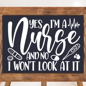 May include: A black chalkboard sign with white text that reads "Yes I'm a Nurse and no I won't look at it". The sign is framed in a brown wooden frame and is sitting on a wooden easel. There are medical symbols on the sign, including a bandage, a pill, a thermometer, and blood drops.