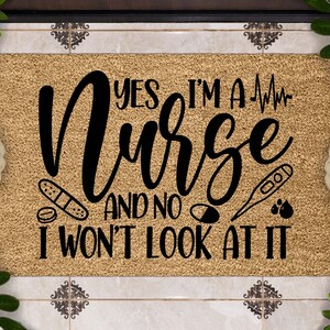May include: A brown coir doormat with the text "Yes I'm a Nurse and no I won't look at it" in black cursive font. The text is surrounded by medical symbols including a heart rate monitor, bandages, pills, a thermometer, and blood drops.