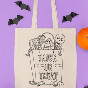 May include: A white canvas tote bag with black outlines of a trick or treat bag filled with sweets, a pumpkin, and a worm. The text "Trick or Treat" is written on the bag. The bag is surrounded by black paper bats and orange pumpkins on a purple background.